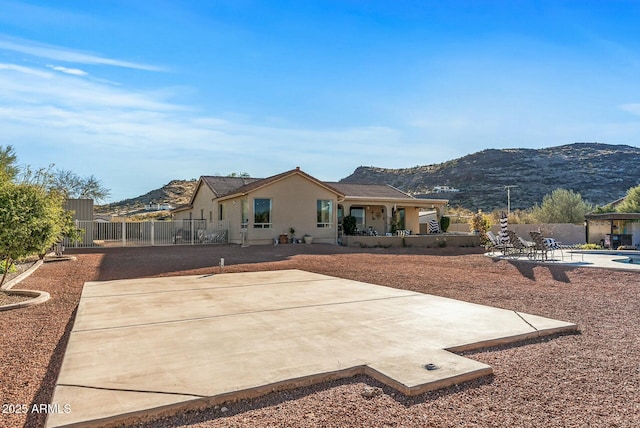 rear view of house with a mountain view and a patio