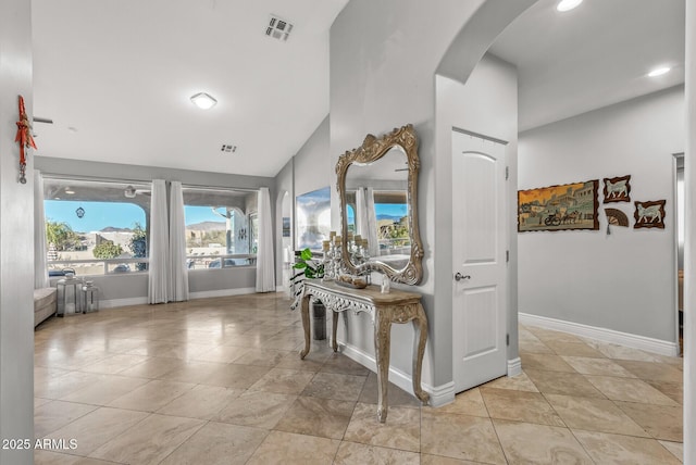 corridor featuring lofted ceiling and light tile patterned floors