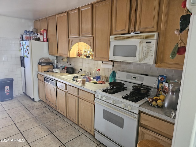 kitchen with decorative backsplash, sink, light tile patterned floors, and white appliances