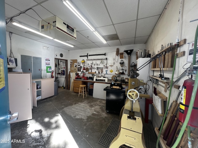 miscellaneous room with a paneled ceiling and a workshop area