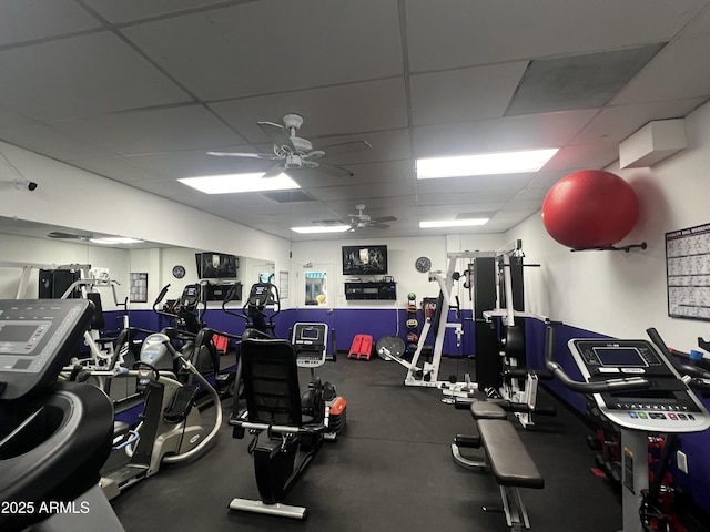 workout area with ceiling fan and a paneled ceiling