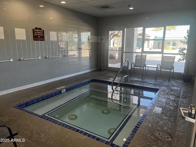 view of swimming pool featuring an indoor hot tub