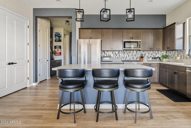 5725 S 101st St, Mesa, AZ 85212 - kitchen with light countertops, a kitchen island, light wood-style floors, and appliances with stainless steel finishes