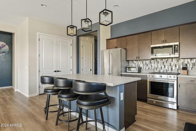 5725 S 101st St, Mesa, AZ 85212 - kitchen with a kitchen bar, appliances with stainless steel finishes, wood finished floors, and light countertops