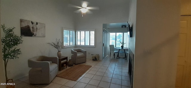 sitting room with light tile patterned flooring, ceiling fan, and baseboards