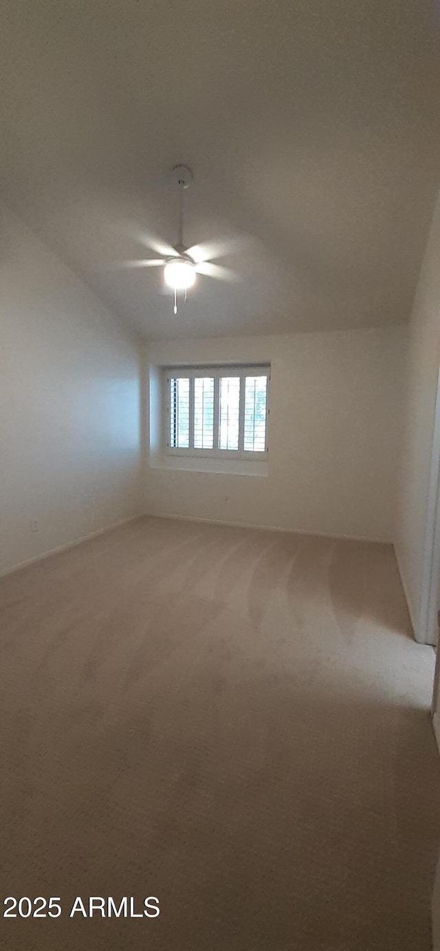carpeted empty room featuring a ceiling fan