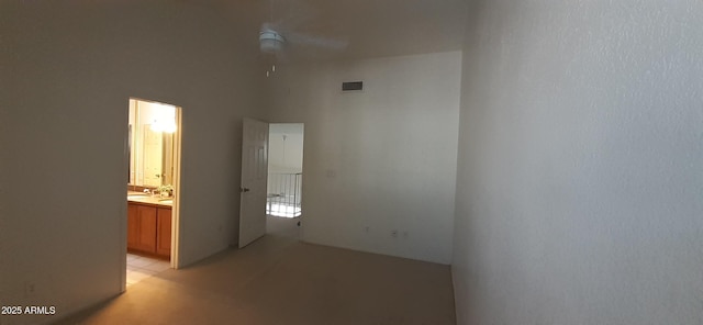spare room featuring ceiling fan and light carpet
