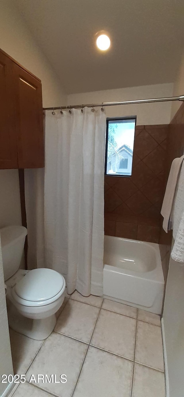 bathroom featuring tile patterned floors, toilet, and shower / bath combination with curtain