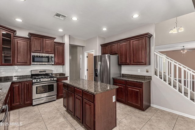 4322 S Ranger Trl, Gilbert, AZ 85297 - kitchen with appliances with stainless steel finishes, a center island, backsplash, a ceiling fan, and light tile patterned floors