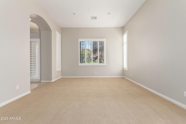 31604 N 19th Ave, Phoenix, AZ 85085 - spare room featuring light carpet, arched walkways, visible vents, and baseboards