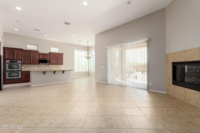 31604 N 19th Ave, Phoenix, AZ 85085 - unfurnished living room with a chandelier, a tiled fireplace, light tile patterned floors, recessed lighting, and visible vents