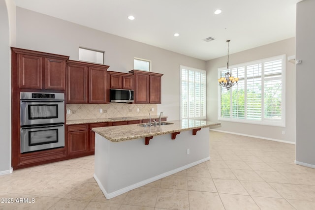 31604 N 19th Ave, Phoenix, AZ 85085 - kitchen featuring a kitchen bar, appliances with stainless steel finishes, light stone counters, a sink, and decorative backsplash