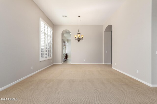 31604 N 19th Ave, Phoenix, AZ 85085 - spare room featuring baseboards, arched walkways, light colored carpet, and an inviting chandelier