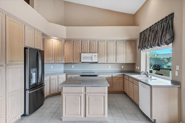 kitchen featuring white appliances, light tile patterned floors, sink, a kitchen island, and light brown cabinets