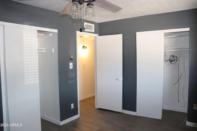 unfurnished bedroom with a closet, ceiling fan, dark hardwood / wood-style flooring, and a textured ceiling