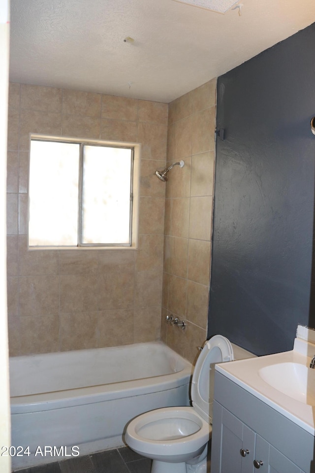 full bathroom with tile patterned flooring, vanity, toilet, and tiled shower / bath