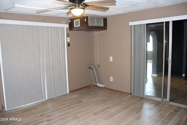 unfurnished room featuring ceiling fan, light hardwood / wood-style flooring, and a textured ceiling