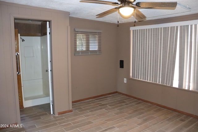 unfurnished room with ceiling fan, crown molding, light wood-type flooring, and a textured ceiling