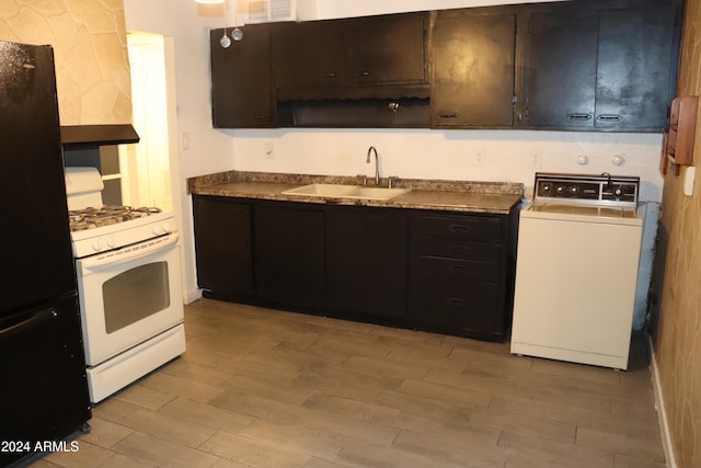 kitchen with black fridge, sink, light hardwood / wood-style flooring, gas range gas stove, and washer / clothes dryer