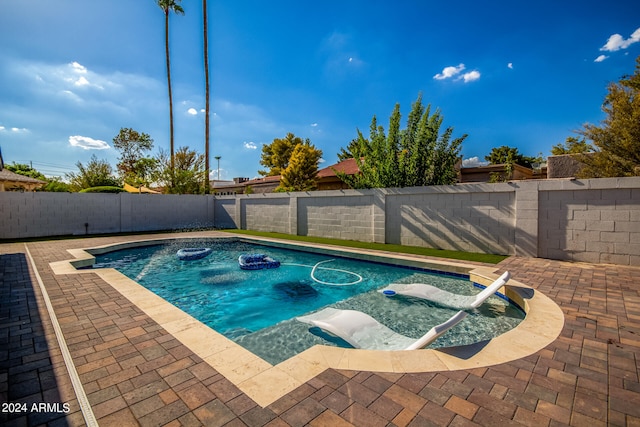 view of swimming pool with a jacuzzi and a patio