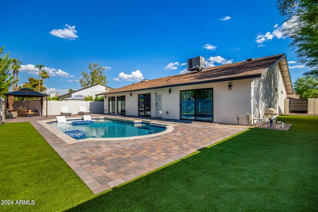 rear view of property with a lawn, a patio, a fenced in pool, and a gazebo