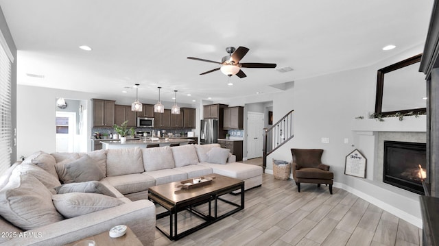 living room with ceiling fan and light hardwood / wood-style floors