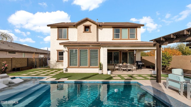 rear view of house with a patio and a fenced in pool