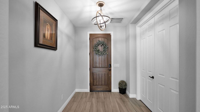 entrance foyer with a chandelier and light wood-type flooring