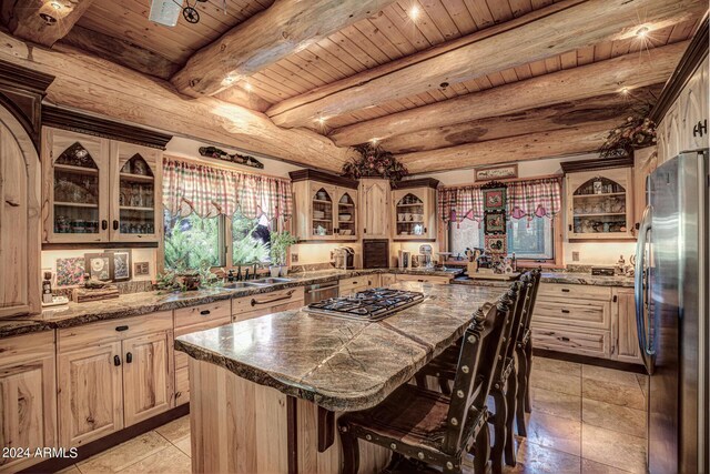 kitchen featuring a breakfast bar area, a kitchen island, stainless steel appliances, wooden ceiling, and beamed ceiling