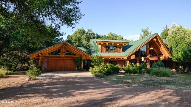 view of front of property featuring driveway and metal roof