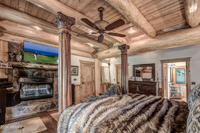 bedroom featuring wood ceiling, decorative columns, beamed ceiling, and a stone fireplace