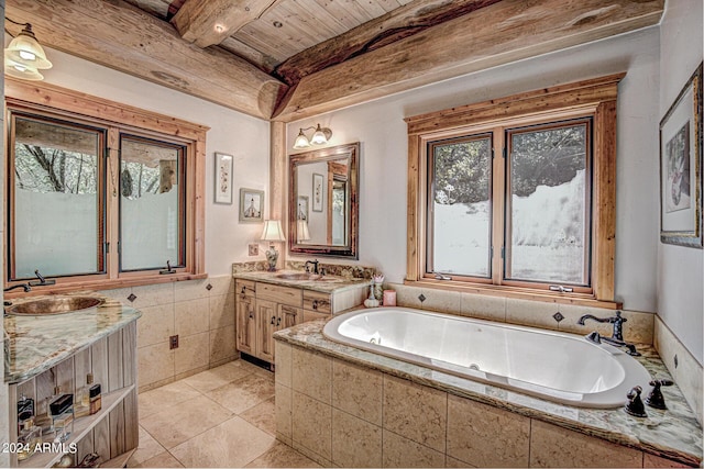 bathroom with beamed ceiling, two vanities, a sink, tile walls, and a bath