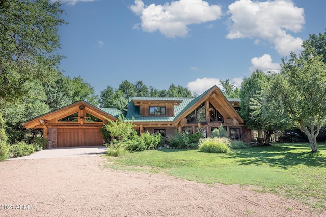 view of front facade featuring a front lawn, dirt driveway, metal roof, a garage, and a standing seam roof