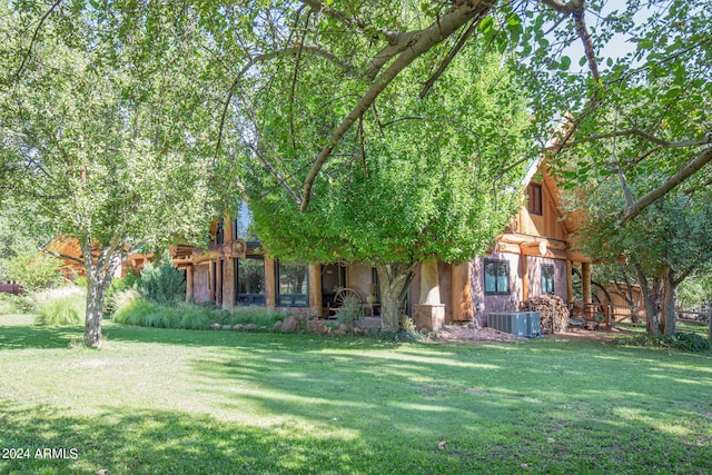 view of front of house with a front lawn, central AC unit, and stone siding