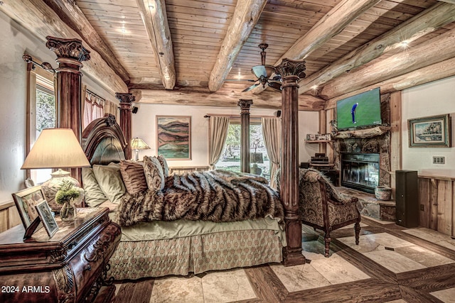 living area featuring a glass covered fireplace, beamed ceiling, wood ceiling, and a ceiling fan