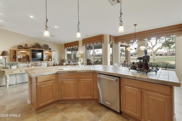 kitchen featuring a kitchen island, dishwasher, sink, hanging light fixtures, and tile counters