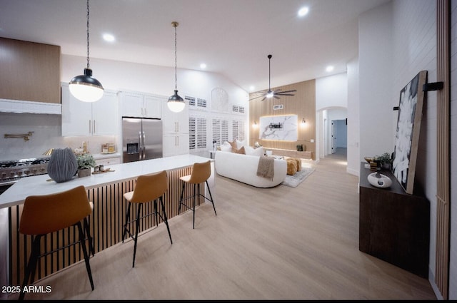802 N Lisbon Dr, Chandler, AZ 85226 - kitchen with stainless steel refrigerator with ice dispenser, a ceiling fan, arched walkways, recessed lighting, and a kitchen bar