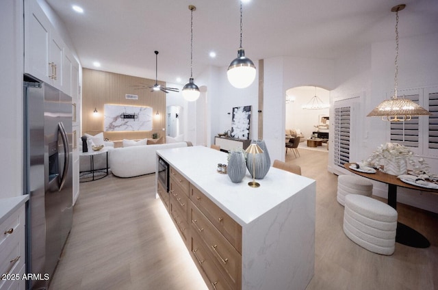 802 N Lisbon Dr, Chandler, AZ 85226 - kitchen featuring stainless steel refrigerator with ice dispenser, ceiling fan, a center island, open floor plan, and arched walkways