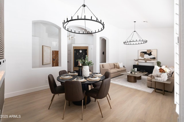 802 N Lisbon Dr, Chandler, AZ 85226 - dining room with a chandelier, light wood-style flooring, arched walkways, and baseboards