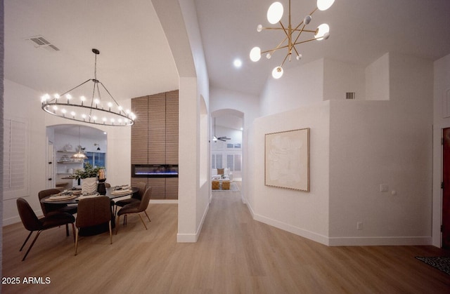 802 N Lisbon Dr, Chandler, AZ 85226 - dining room with a chandelier, arched walkways, light wood-type flooring, high vaulted ceiling, and baseboards