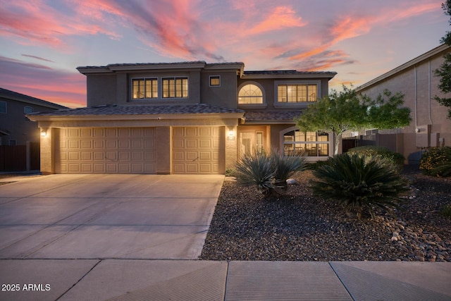 view of front of home with stucco siding, a garage, and concrete driveway
