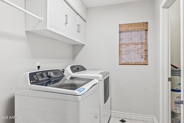 laundry room featuring baseboards, washing machine and clothes dryer, and cabinet space