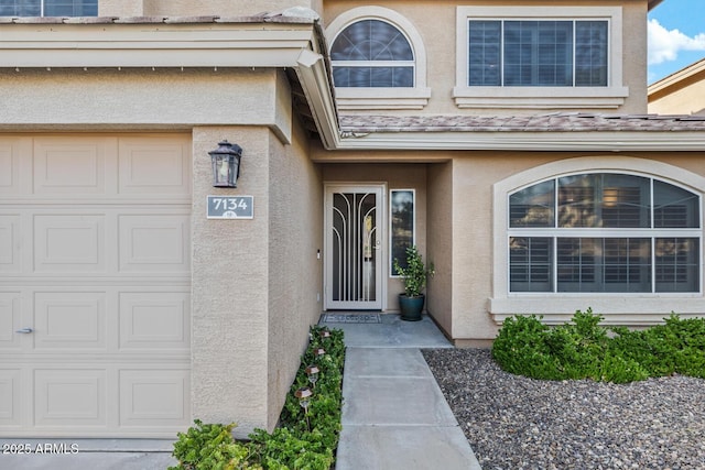 property entrance featuring stucco siding and a garage