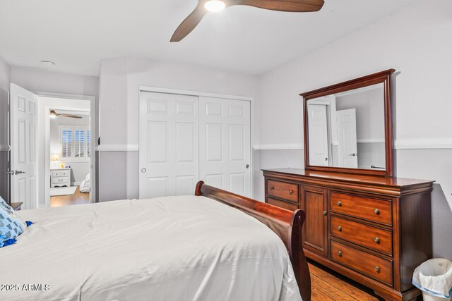 bedroom featuring a ceiling fan, a closet, and wood finished floors