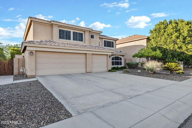 view of front of property featuring concrete driveway, stucco siding, fence, and an attached garage