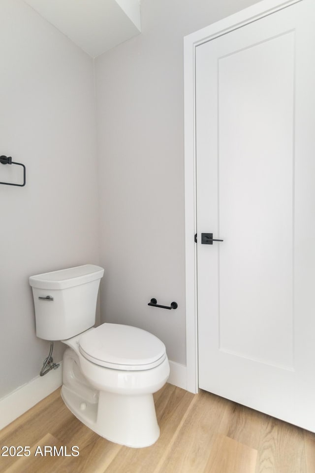 bathroom with toilet and hardwood / wood-style floors