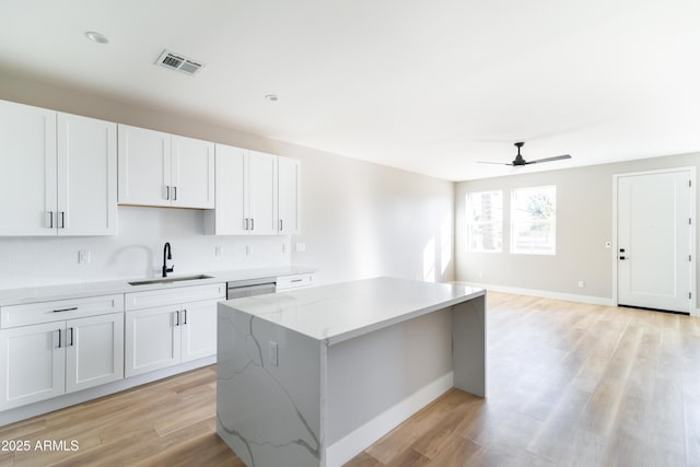 kitchen featuring a center island, sink, and white cabinets