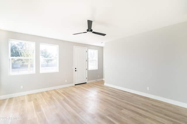 empty room with ceiling fan and light hardwood / wood-style floors