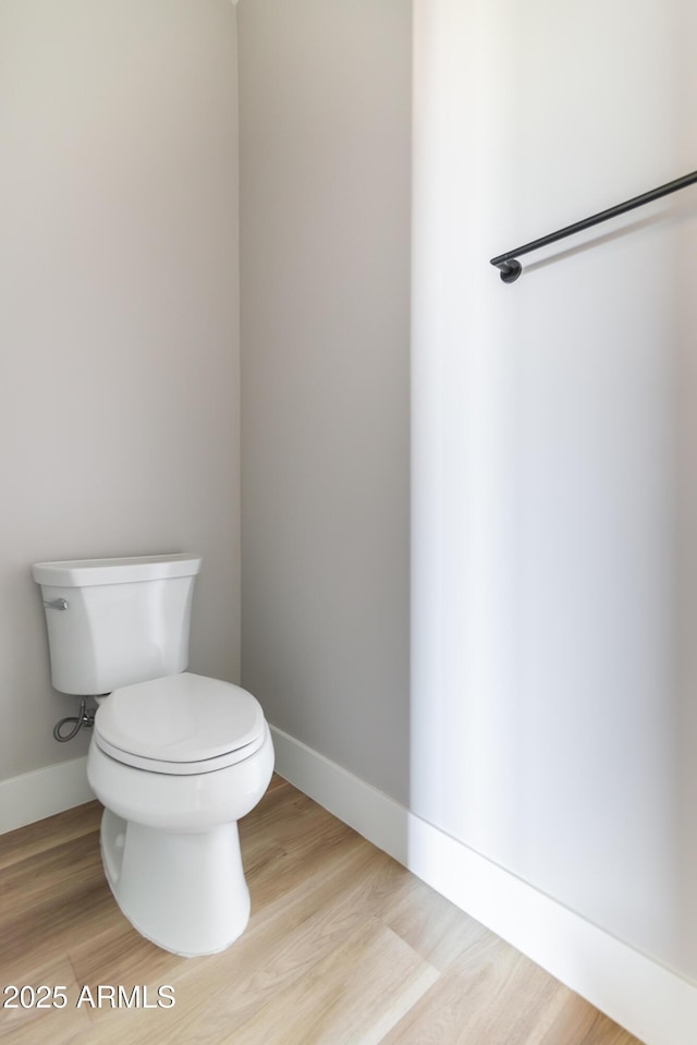 bathroom featuring wood-type flooring and toilet