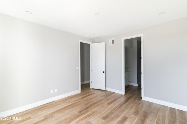 unfurnished bedroom featuring light hardwood / wood-style flooring, a walk in closet, and a closet